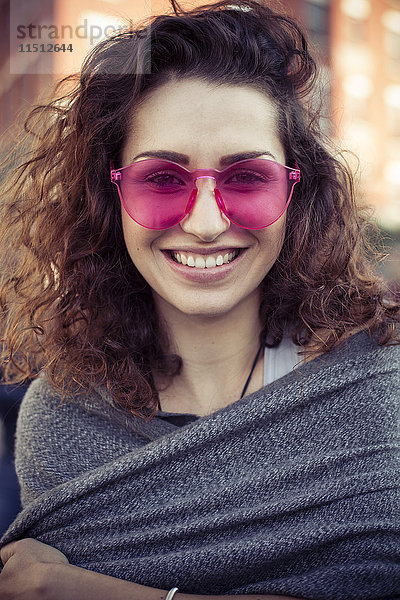 Frau mit rosa Sonnenbrille,  fröhlich lächelnd,  Portrait