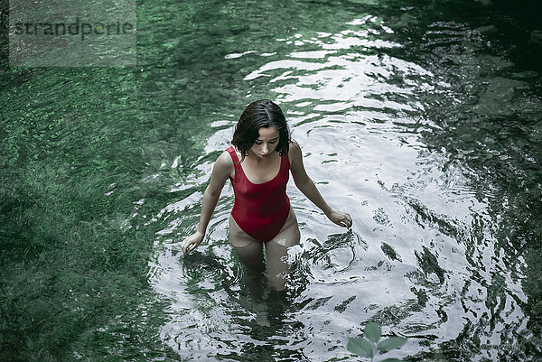Kaukasische Frau watet in einem Wasserbecken