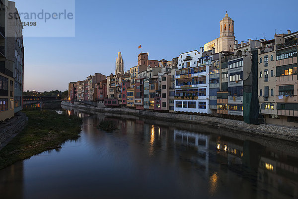 Spanien,  Girona,  Basilika San Felix und Kathedrale Santa Maria hinter Häusern am Fluss Onyar am Abend