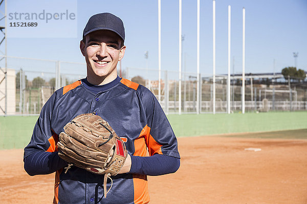 Porträt eines lächelnden Baseballspielers mit einem Baseballhandschuh