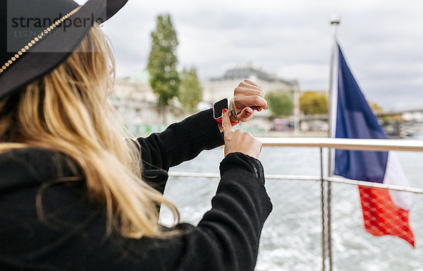 Paris,  Frankreich,  Touristen,  die mit smartwatch eine Kreuzfahrt auf der Seine machen.