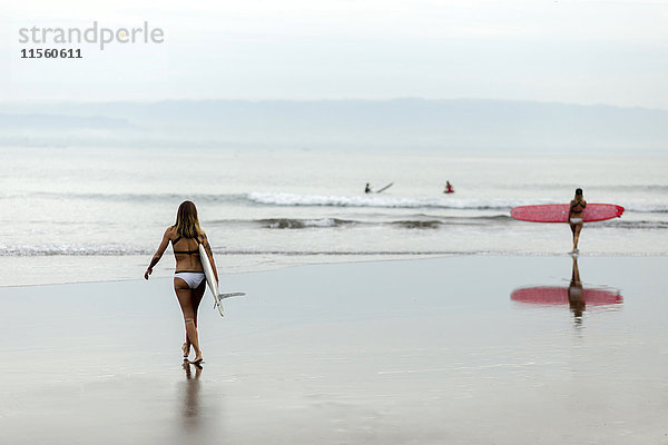 Frau mit Surfbrett am Meer
