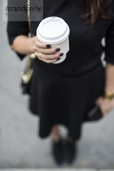 Frauenhand mit Kaffee zum Mitnehmen