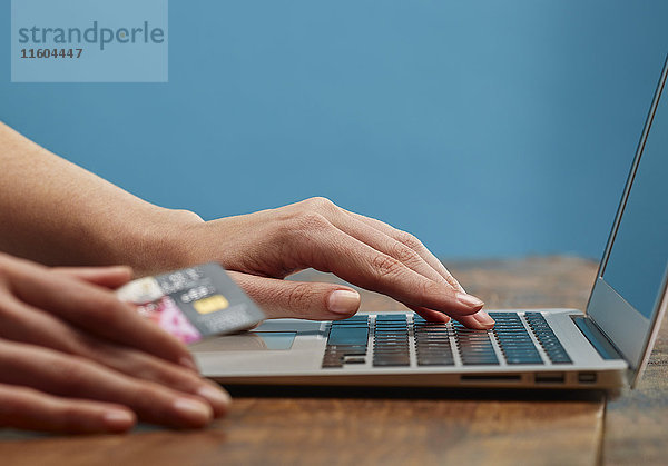 Hände einer Frau beim Online-Shopping mit Laptop