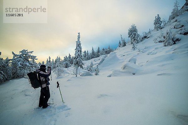 Kaukasischer Mann fotografiert verschneiten Berg