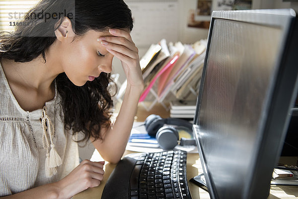 Frustrierte hispanische Frau am Computer
