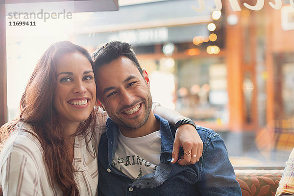 Portrait glückliches junges Paar beim Umarmen im Cafe