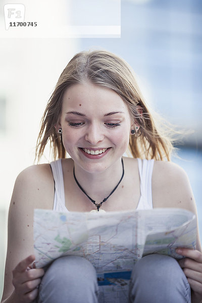 Ein junges Mädchen,  das allein reist und sich die Karte ansieht.
