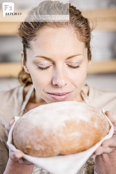 Frau hält Brot in der Hand