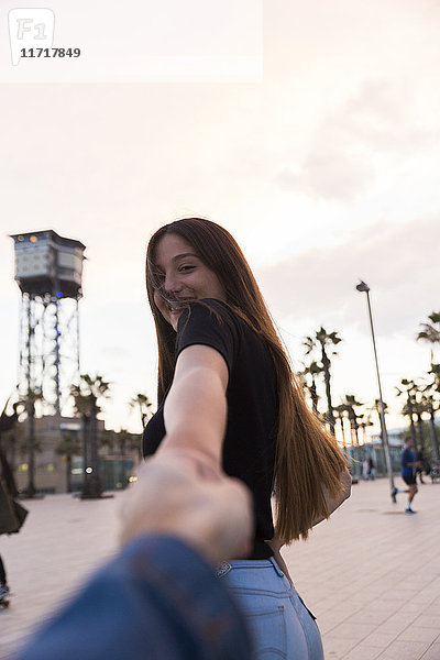Spanien,  Barcelona,  glückliche junge Frau hält Hand