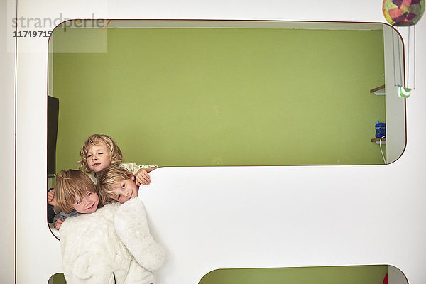 Drei Jungen zusammen auf der obersten Koje der Etagenbetten,  Kopf und Schultern