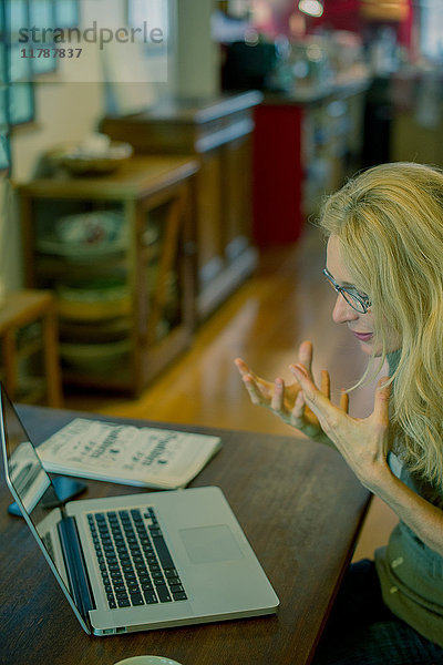Frau mit Laptop-Computer und Gestik in Frustration