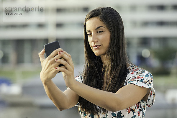 Frau nimmt Selfie mit Smartphone