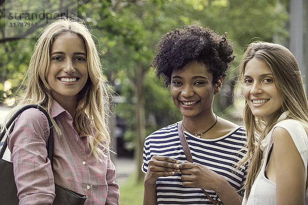 Junge Frauen lächeln gemeinsam im Freien,  Porträt