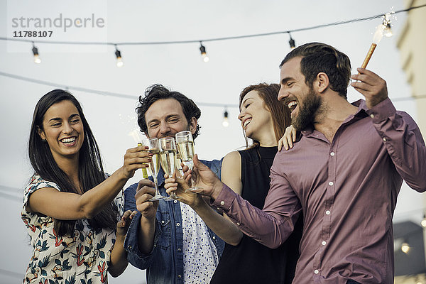 Freunde klirren an Champagnergläsern im Freien.