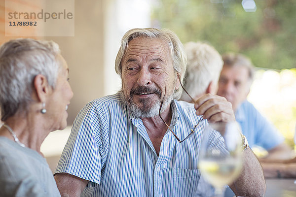 Porträt eines älteren Mannes,  der einer älteren Frau zuhört.