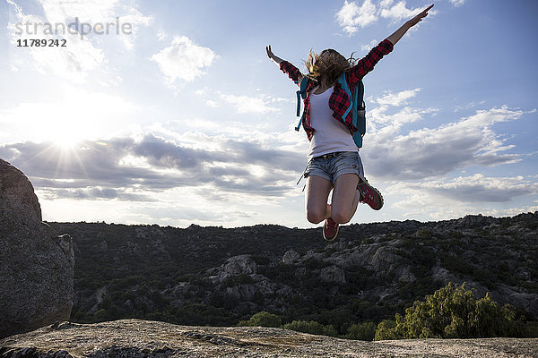 Spanien,  Madrid,  junge Frau beim Springen während eines Trekking-Tages