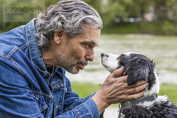 Älterer Mann im Gespräch mit seinem Hund
