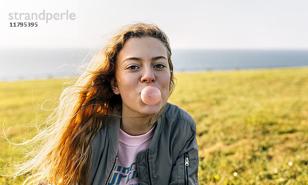 Teenager-Mädchen macht eine Kaugummiblase im Freien