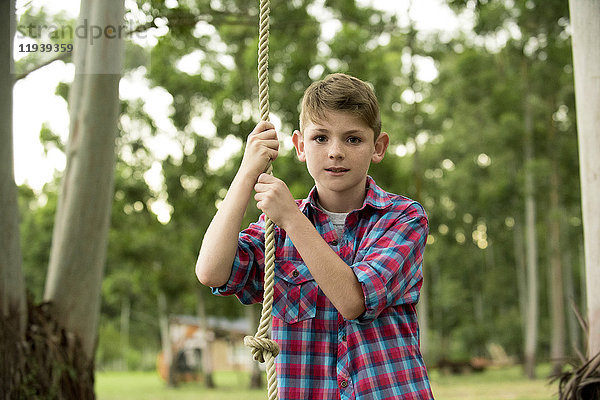 Junge auf Seilschaukel,  Portrait