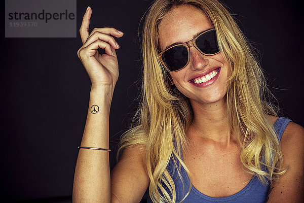 Junge Frau mit Sonnenbrille,  fröhlich lächelnd,  Portrait
