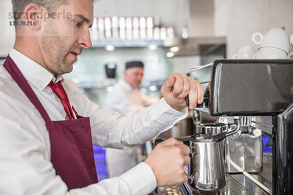 Kellner im Restaurant mit Kaffeemaschine