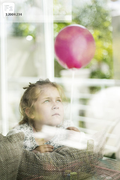 Portrait des Mädchens mit Ballon hinter dem Fenster
