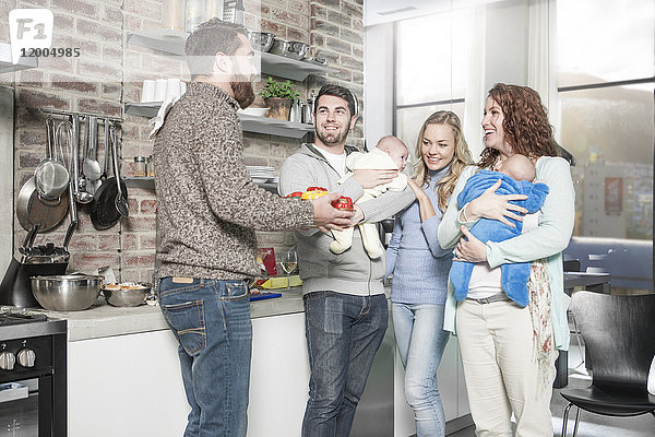 Familie und Freunde mit Babys in der Küche