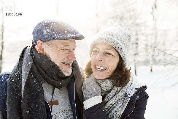 Porträt eines glücklichen Seniorenpaares in der Winterlandschaft