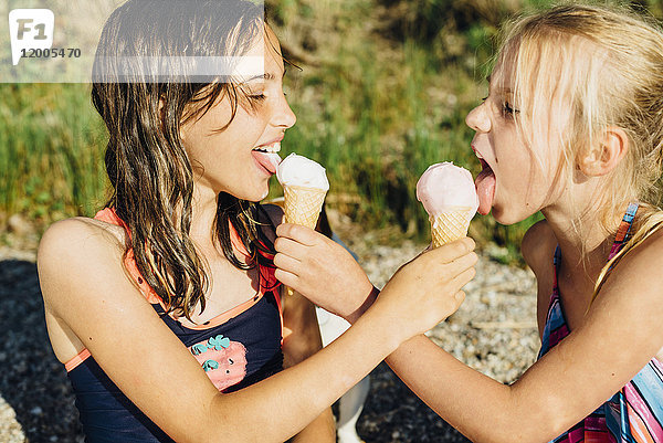 Zwei Mädchen beim Eis essen am Strand