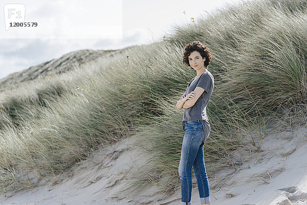 Porträt einer selbstbewussten Frau,  die in der Stranddüne steht.