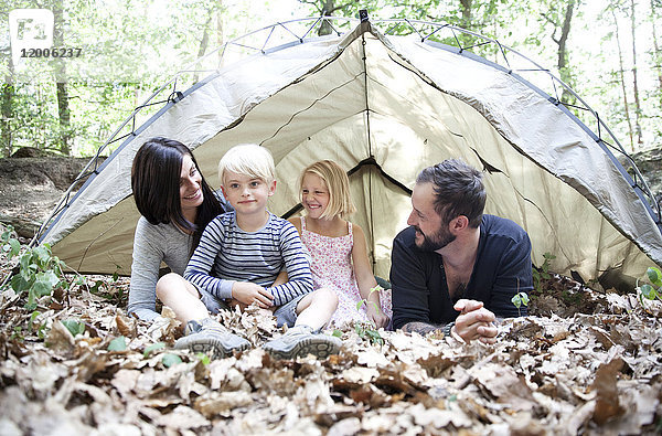 Glückliche Familie mit Zelt im Wald