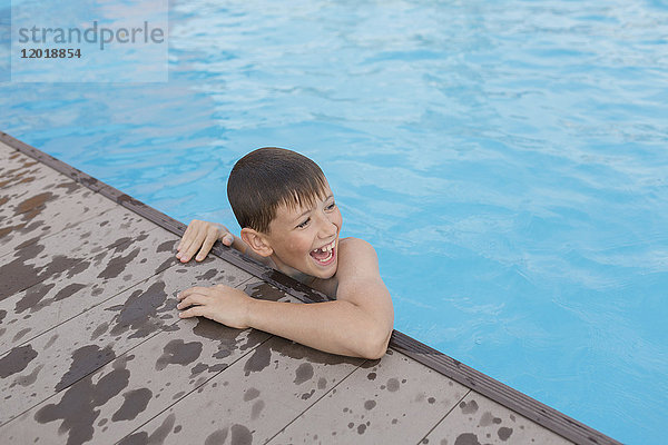 Hochwinkelansicht eines fröhlichen,  hemdlosen Jungen im Schwimmbad