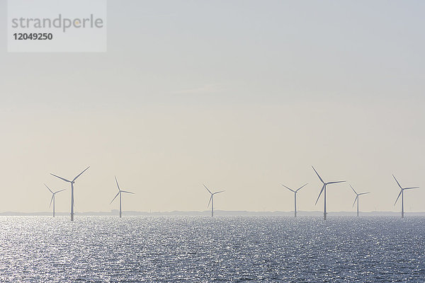 Offshore-Windkraftanlagenpark mit Sonnenschein auf der Nordsee an einem dunstigen Morgen,  Vereinigtes Königreich