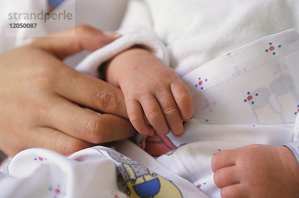 Die Hände von Baby und Mutter