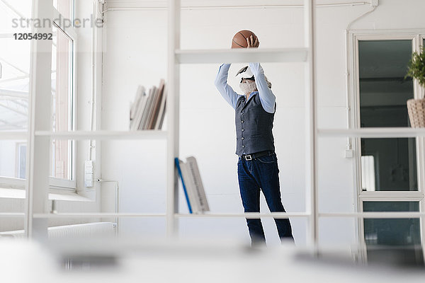 Erwachsener Mann mit VR-Brille beim Basketballspielen im Büro