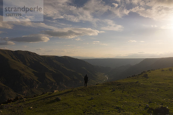 Entfernter kaukasischer Mann,  der die malerische Aussicht auf ein Tal bewundert