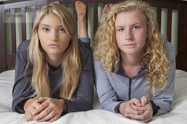 Zwei Teenager-Mädchen mit blondem Haar liegen auf einem Bett und posieren für die Kamera; Connecticut,  Vereinigte Staaten von Amerika