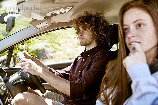 Junger Mann mit Freundin beim Autofahren