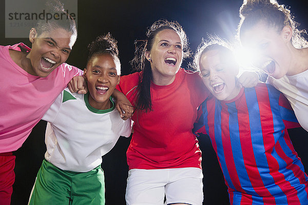 Portrait begeisterte,  selbstbewusste junge Fußballmannschaft,  die sich zusammenschließt und jubelt.