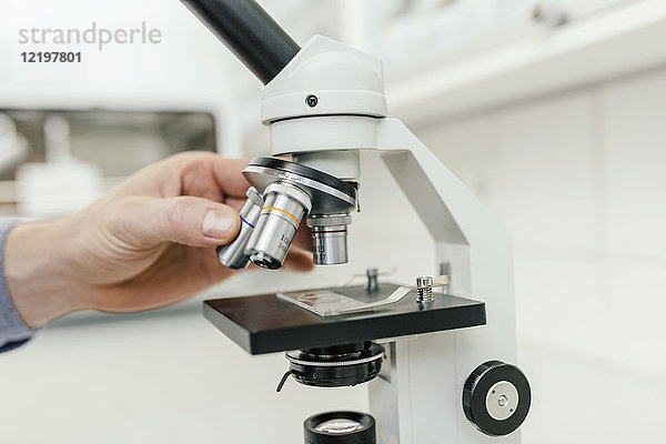 Nahaufnahme des Laboranten mit dem Mikroskop im Labor