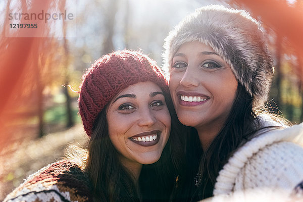Selfie von zwei glücklichen hübschen Frauen in einem herbstlichen Wald
