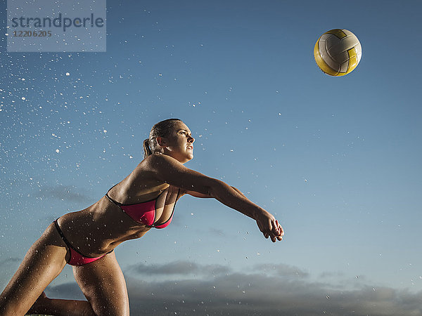 Kaukasische Frau taucht zum Volleyball