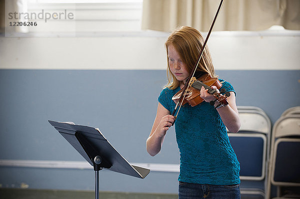 Kaukasisches Mädchen übt Geige