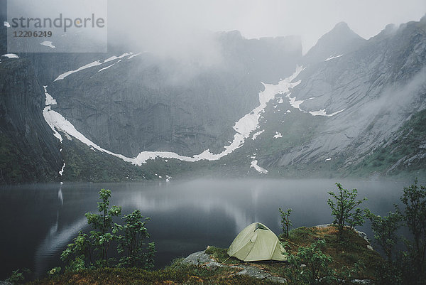 Campingzelt am Fluss im Nebel