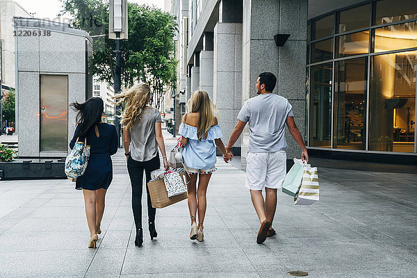 Freunde tragen Einkaufstaschen in der Stadt