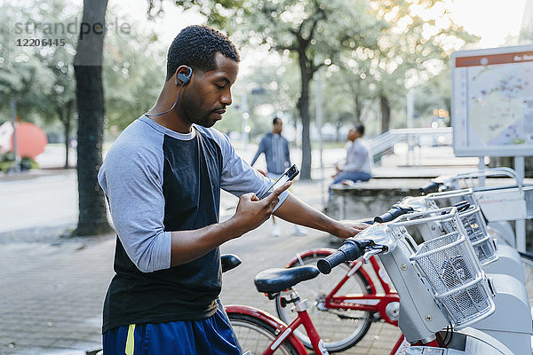 Schwarzer Mann zahlt mit Handy für Fahrradverleih