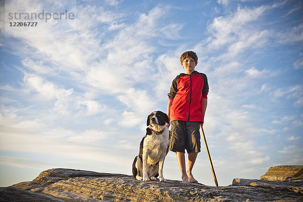 Kaukasischer Junge beim Wandern mit Hund