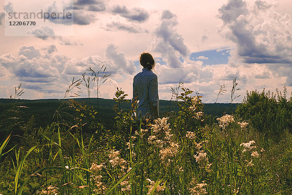 Frau in einem Feld mit Wildblumen stehend