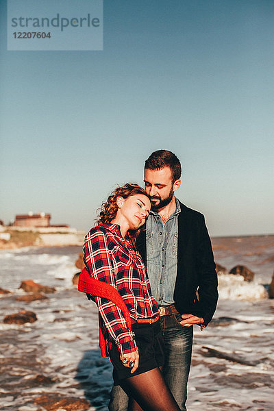 Romantisches Paar mittlerer Erwachsener am Strand stehend,  Oblast Odessa,  Ukraine